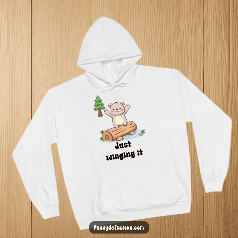 Funny hoodie featuring a clumsy bear attempting to balance on a slippery log, arms out wide, for cozy laughs.