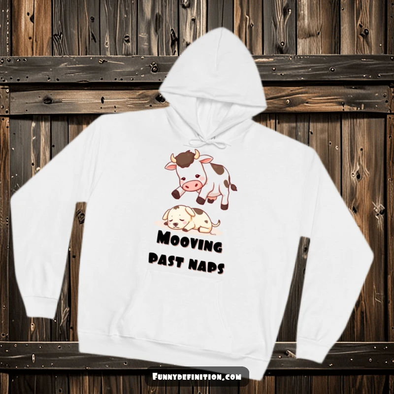 Funny hoodie showing a cow trying to jump over a tiny sleeping dog, providing warmth and farmyard-themed amusement.